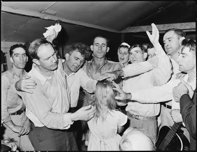 Members of the Pentecostal Church of God in Lejunior, Harlan County, Ky., lay hands on and pray for a worshiper in 1946; not a convention service. (File photo)