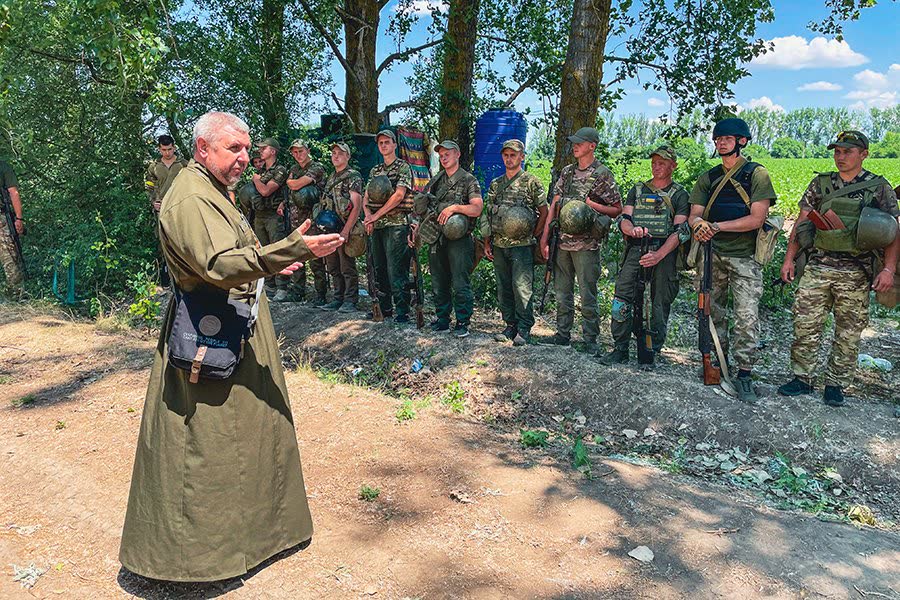 A Ukrainian military chaplain speaks with National Guard soldiers in 2022; not a person named in this story. (File photo)